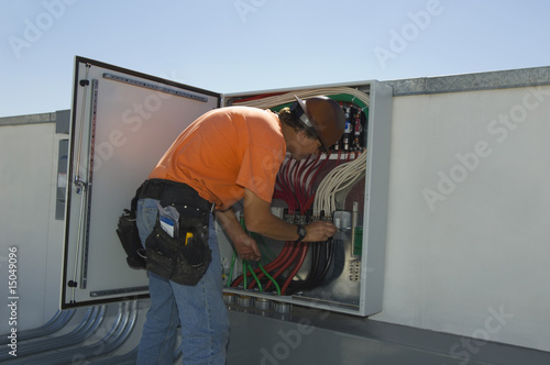 Photo: Engineer Working on Electrical Box at Solar Power Plant Engineer Working on Electrical Box at Solar Power Plant