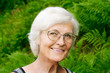Seniorin vor Farnkraut