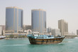 Photo: dubai uae a dhow old wooden sailing vessel cruises down dubai creek in front of the rolex tower. dubai uae a dhow old wooden sailing vessel cruises down dubai creek in front of the rolex tower.