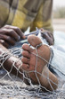 Photo: fujairah uae a local fisherman fixes holes and tangles in his net in fujairah. fujairah uae a local fisherman fixes holes and tangles in his net in fujairah.
