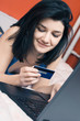 Photo: Young woman shopping online with a credit card Young woman shopping online with a credit card