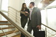 Businessman and businesswoman on staircase arguing over document