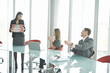 Businesswoman bringing pizza to business people at desk