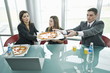 Business people sharing pizza at desk