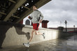 Foto: Young man jogging besides the Thames in London on stormy day Young man jogging besides the Thames in London on stormy day