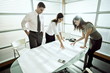 Professionals looking at architectural plans on desk