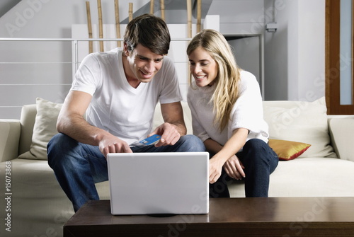Foto: Young couple at laptop computer with credit card Young couple at laptop computer with credit card