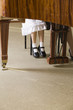 Low section of child and teacher at piano