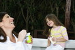 Young woman and girl having breakfast outdoors