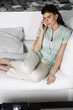 Young woman on couch talking on phone