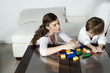 Young woman and boy playing with building blocks
