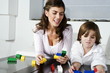 Young woman and boy playing with building blocks