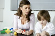 Young woman and boy playing with building blocks