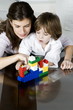 Young woman and boy playing with building blocks