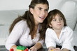Young woman and boy playing with building blocks