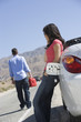 woman waiting for man to refuel car