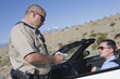 Police officer checking on driver in desert