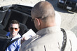 Police officer checks male drivers papers