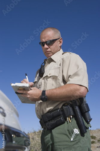 Photo: Policeman writing speeding ticket Policeman writing speeding ticket