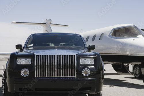 Photo: Limousine and private jet on landing strip. Limousine and private jet on landing strip.
