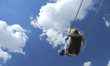 Girl swinging against a blue sky