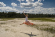 A girl leaping on a sandy beach