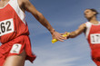 Athletes passing relay baton