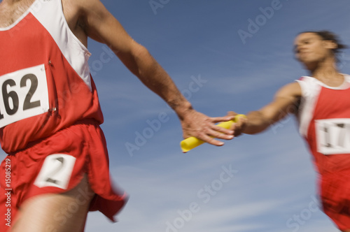 Photo: Athletes passing relay baton Athletes passing relay baton
