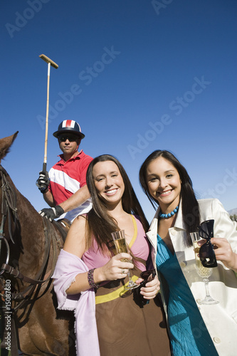 Foto: Two women toasting on polo field, portrait Two women toasting on polo field, portrait