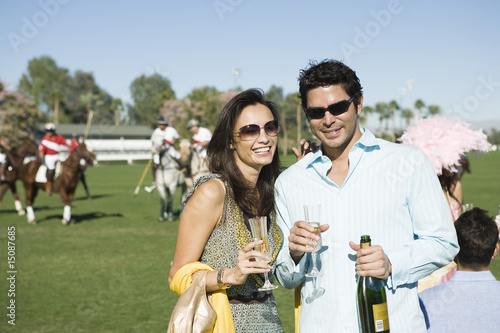 Photo: Couple toasting on polo field, portrait Couple toasting on polo field, portrait