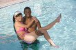 Young Man Carrying Young Woman in Swimming Pool, Portrait