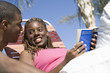 Young Couple Reading Under Palm Tree