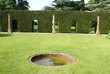 topiary hedge with openings. pond. columns. shape