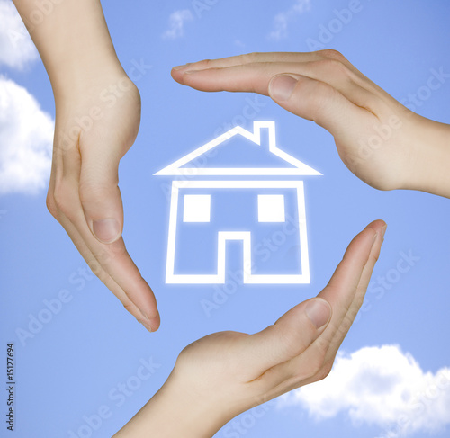 schützende Hände um ein Haus