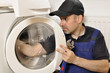 Foto: Handwerker repariert Waschmaschine Handwerker repariert Waschmaschine