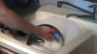 Hands washing a pot in a sink wide view Hands washing a pot in a sink wide view