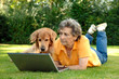 Seniorin am Laptop mit Hund Seniorin am Laptop mit Hund