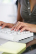 Main d'une femme tapant sur un clavier d'ordinateur de bureau
