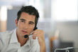 Portrait d'un homme assis à un bureau avec un micro-casque