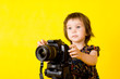 Foto: Baby girl holding photo camera Baby girl holding photo camera