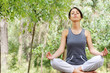 young woman in green forest, yoga and meditation