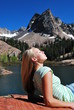 A beautiful woman enjoying the sun up at a mountain lake.