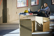 Worker in unfinished office space with feet up on folding table