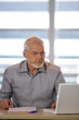 Homme assis à un bureau devant un ordinateur portable