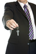 Businessman hands over key after sale of car, flat, house