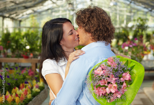 Photo: couple kissing in flower nursery couple kissing in flower nursery