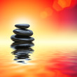 Stack of zen stones over red water background