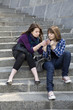 Two urban teen girls sitting on stairs and smoking Two urban teen girls sitting on stairs and smoking