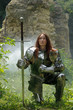 Kämpferin Jeanne D´Arc mit Schwert und Plattenrüstung knieend