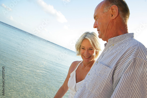 Portrait d'un couple de seniors se baladant au bord de la plage